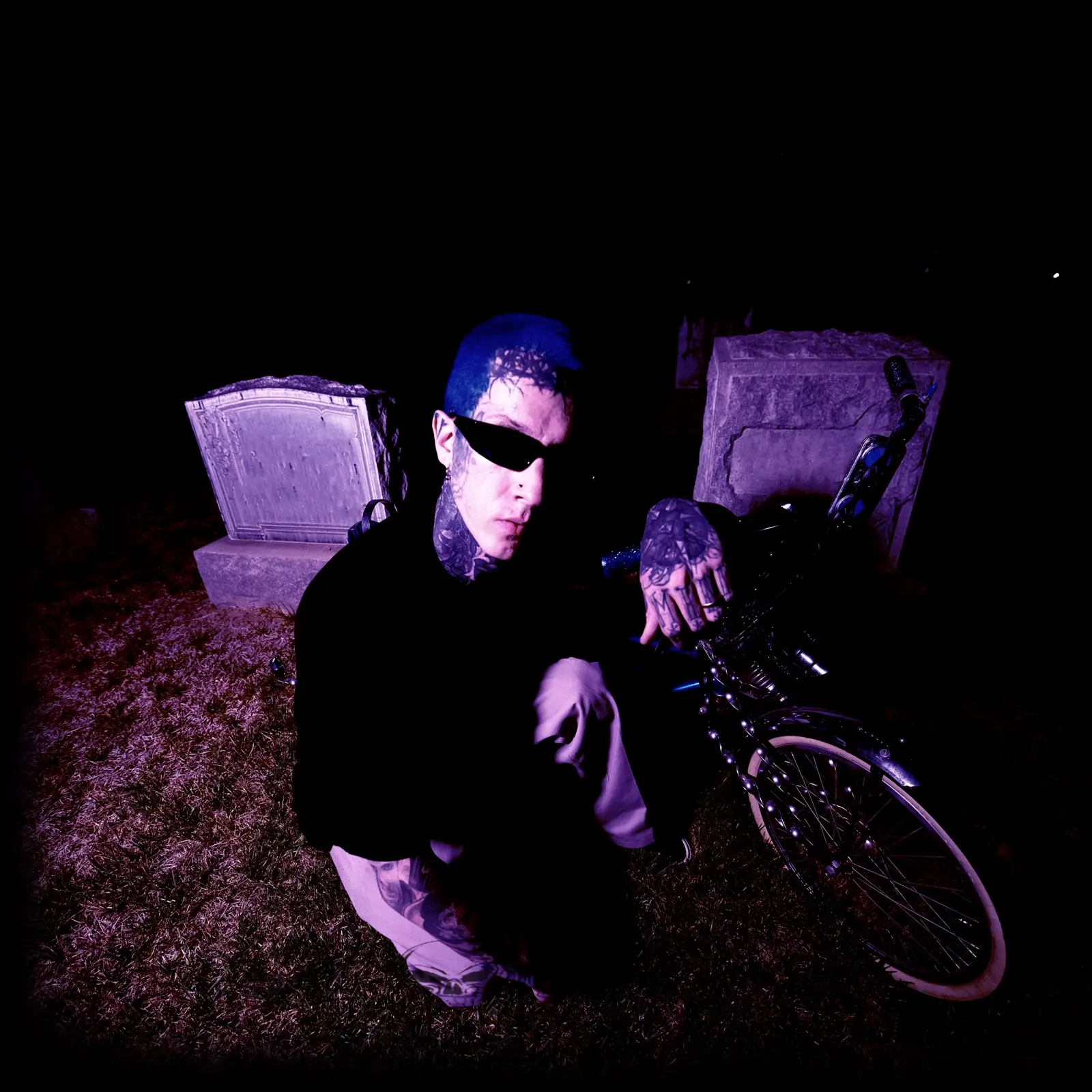 GVLLOW in a nighttime portrait beside a motorcycle